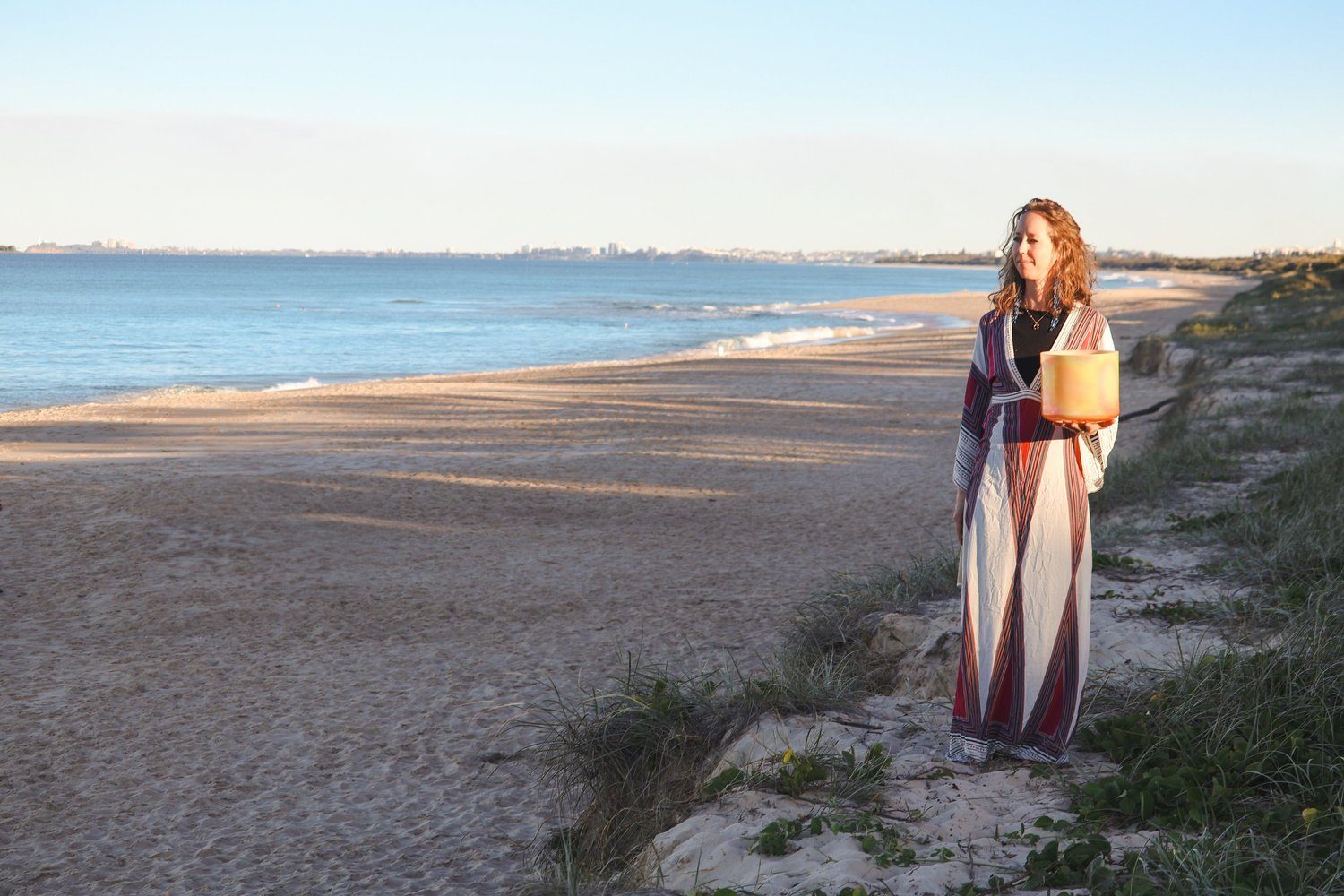 Mira Mi standing at the ocean at dusk