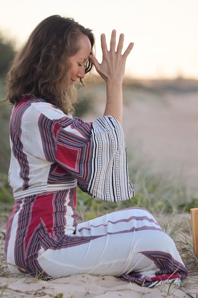 Mira Mi in prayer by the water in traditional dress
